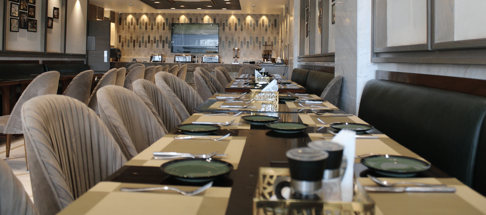 A well-arranged dining space featuring tables with chairs and neatly set cutlery at  BluSalzz Residence, Amritsar
